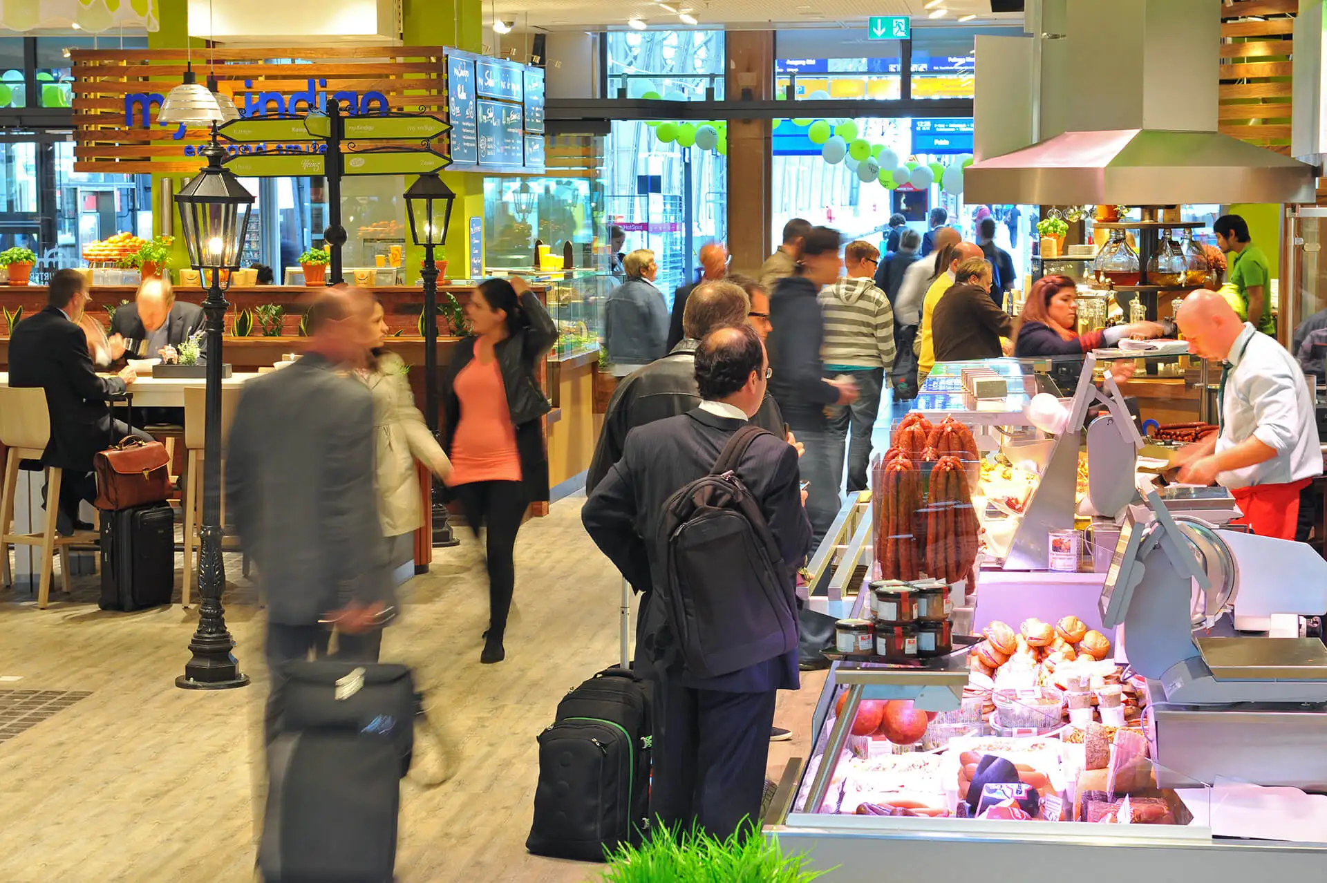 Reisende stehen vor Imbiss- und Einkaufsläden im Frankfurter Bahnhof