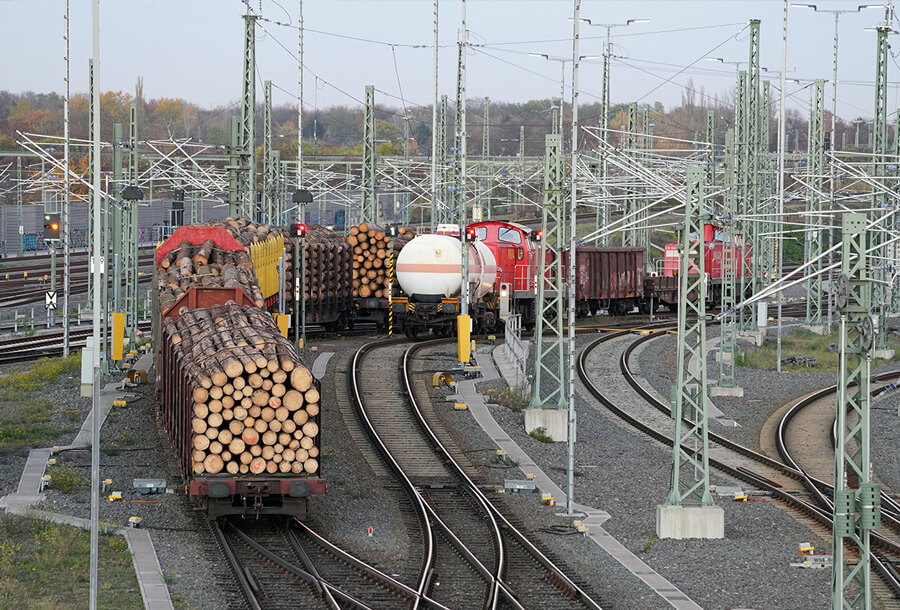Güterverkehr DB: Güterwagenmit offenen Seiten bieten beim Transport extra viel Frischluft. Hier fahren ganze Holzstämme mit.