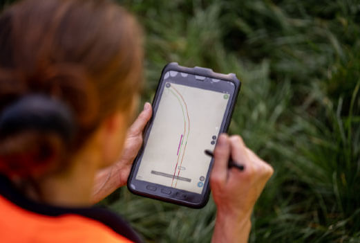 Eine Frau schaut auf eine Geländekarte auf einem Smartphone