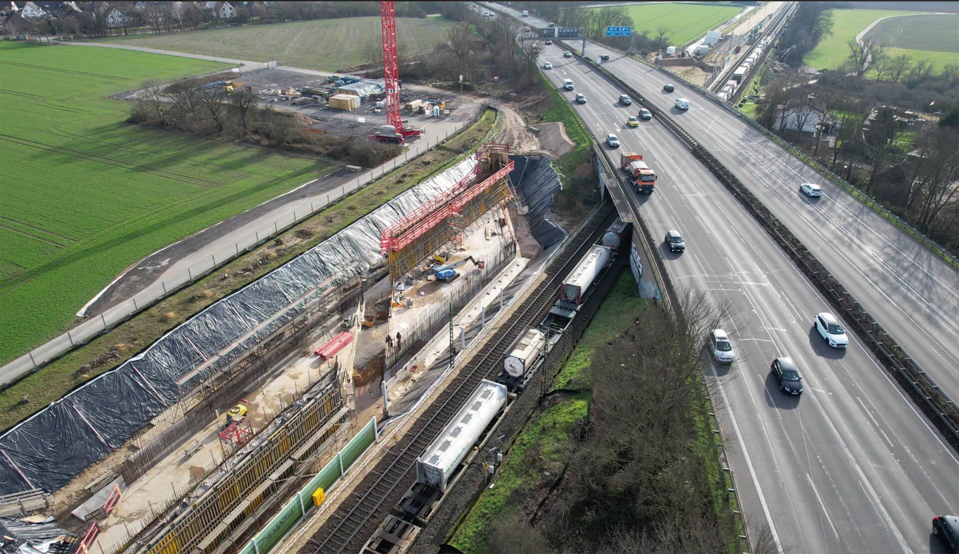 Blick von oben auf eine Autobahn und Bahntunnelarbeiten